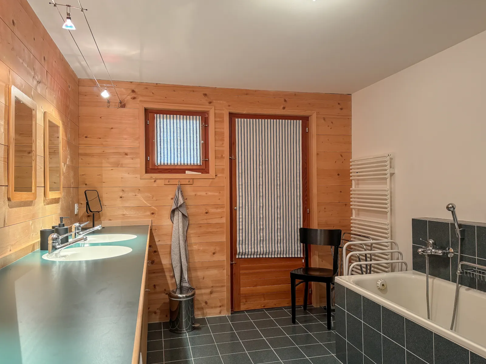 Waschtisch mit zwei Lavabos vor holzgetäfelter Wand im Bad